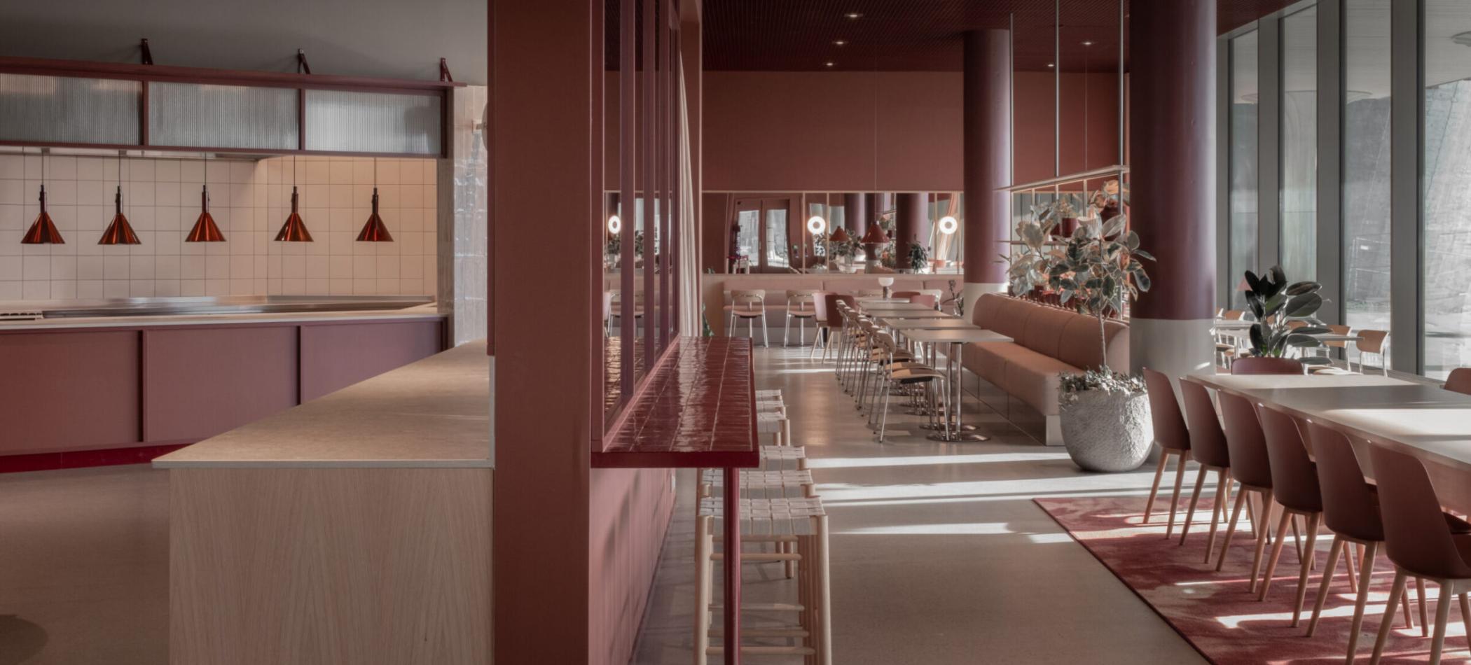 Romlig rytme. Langs vindusfasaden veksler det mellom sittegrupper, beplantning og tekstile flater &ndash; med en varm, sanselig palett som binder det hele sammen.