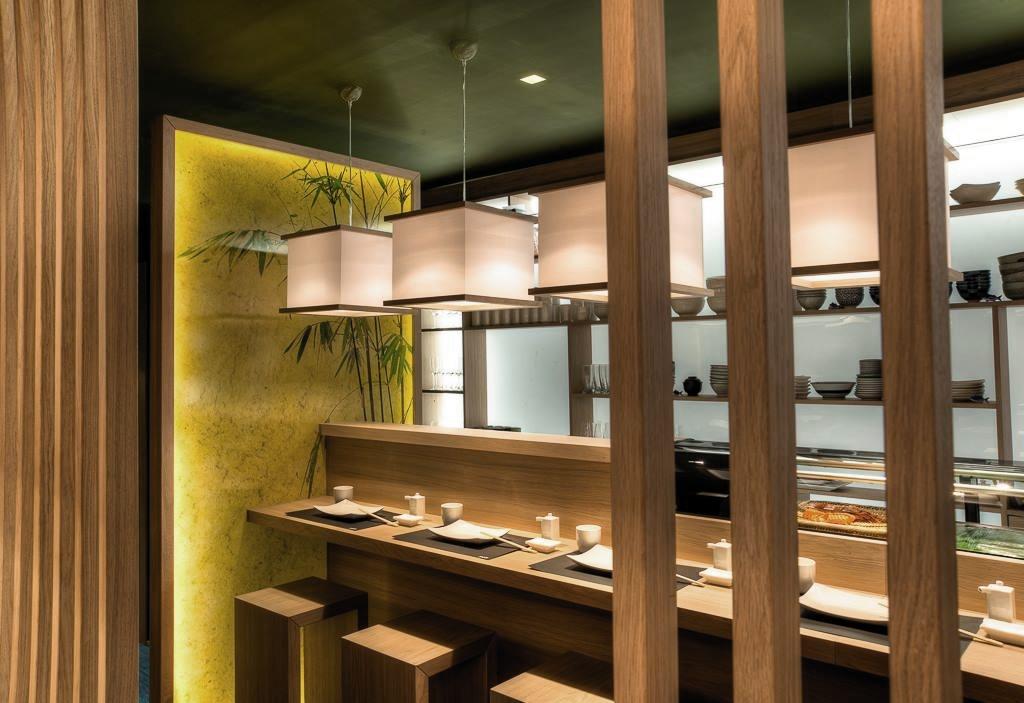 Lang disk i heltre med integrert kj&oslash;lemonter, dempet belysning og varme fargetoner.