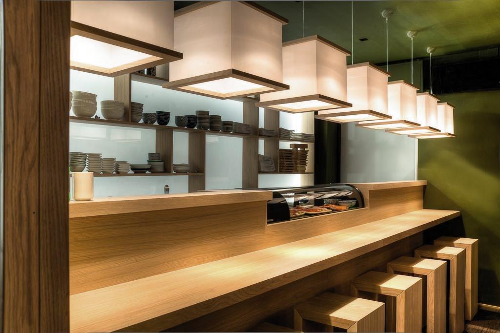 Lang disk i heltre med integrert kj&oslash;lemonter, dempet belysning og varme fargetoner.