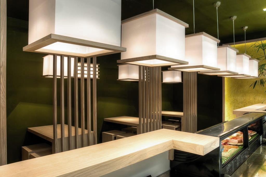 Smale trestrukturer som deler rommet og gir dybde og struktur i sushi-barens interi&oslash;r.